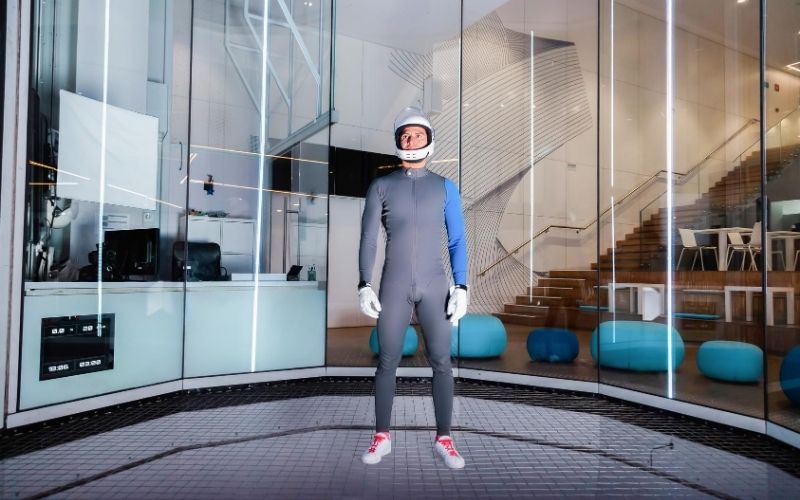 Man in indoor skydiving facility.