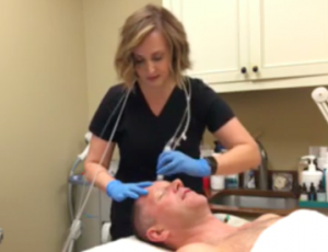 Tonya Grismer L.M.E. exfoliates David’s skin to prep it for the Hyaluronic Acid. 