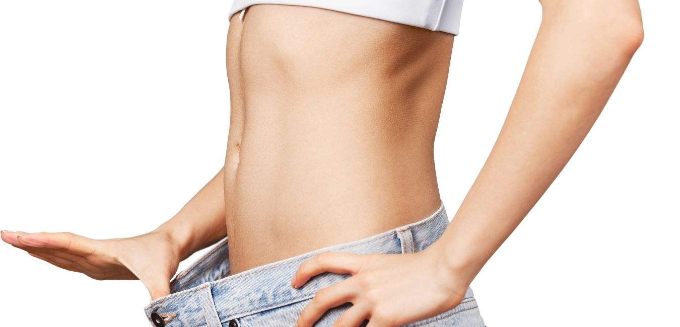 Woman pulling front of jeans showing her trim belly