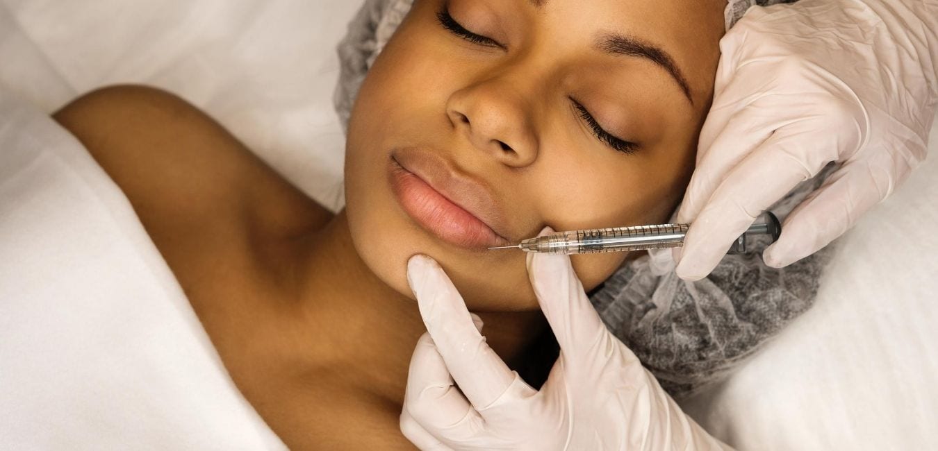 Woman getting lip injections.